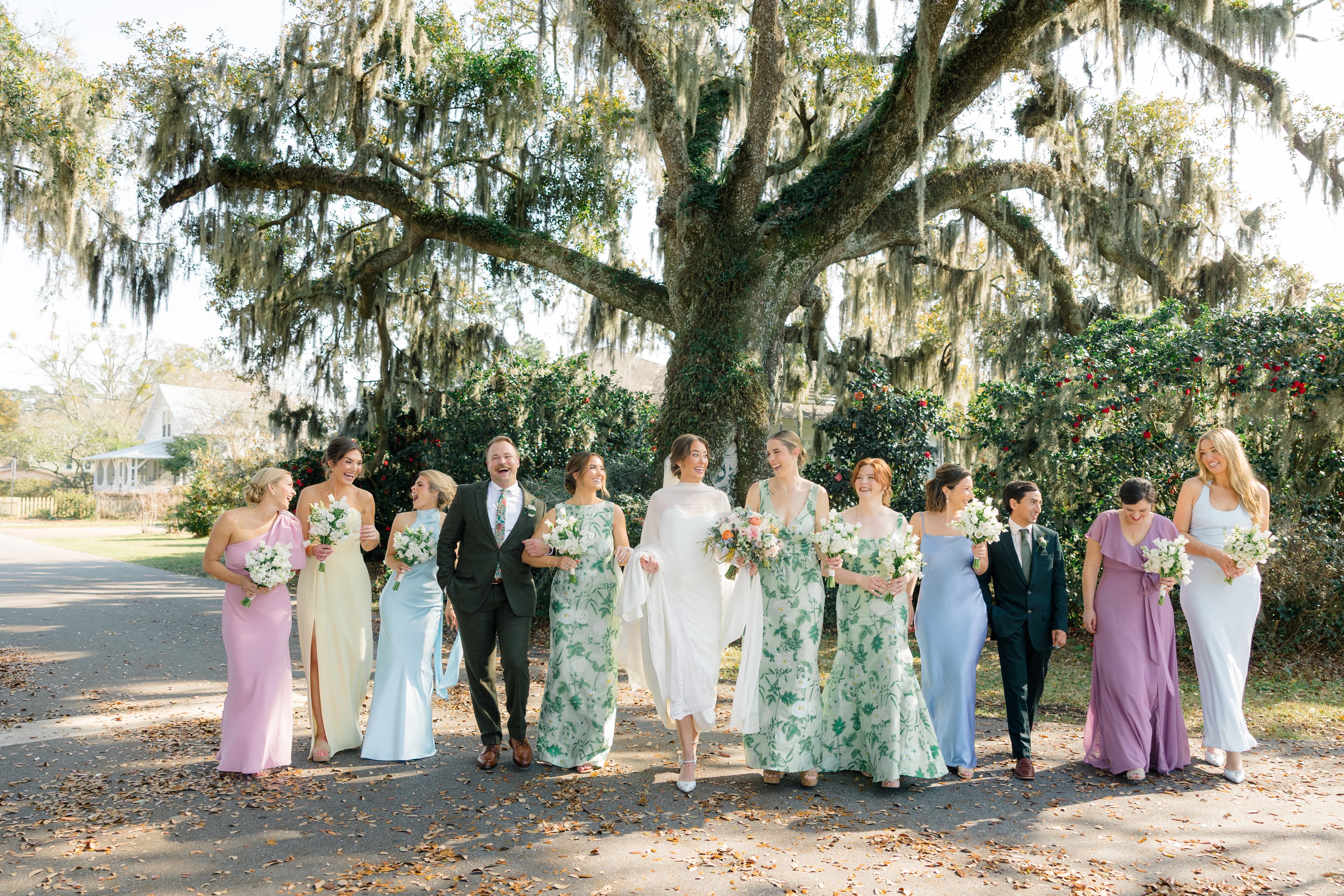 Bride and wedding party walking beneath live oak trees after a Fairhope wedding at St. James Episcopal Church.